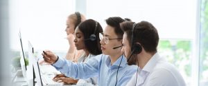 Customer support service. Hotline operator helping his colleague at call centre office